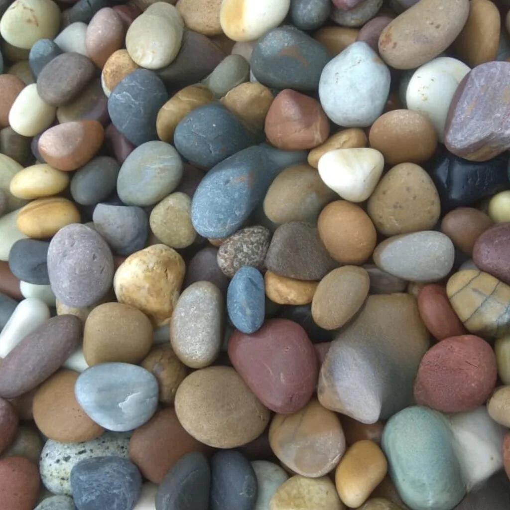 Unpolished natural river stones in earth tones for garden borders, water features, and sustainable landscaping by Stone & Rock Pebbles.